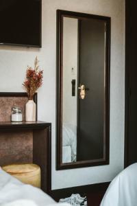 a mirror on a wall next to a bed at La Maison Montparnasse in Paris