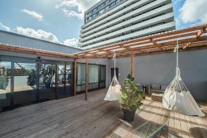 a balcony with two hanging hammocks on a building at Zaliakalnio terasos apartamentai in Kaunas