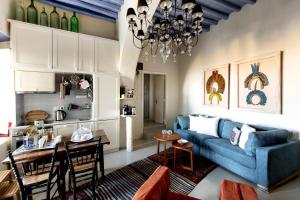 a living room with a blue couch and a table at Tinos E-houses in Triandáros