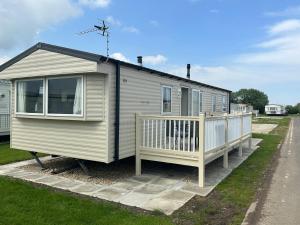 a tiny house with a porch and a fence at Sunnymede 2 Keyshare Holiday lets in Skegness