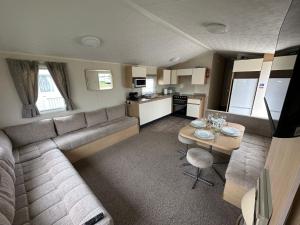 een woonkamer met een bank en een tafel bij Sunnymede 2 Keyshare Holiday lets in Skegness