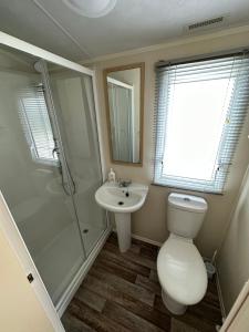een badkamer met een toilet, een wastafel en een douche bij Sunnymede 2 Keyshare Holiday lets in Skegness