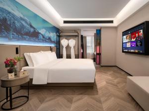 Postel nebo postele na pokoji v ubytování Echarm PLUS International Hotel Zhujiang New Town Wuyangcun Metro Station Branch- Free Deliver Service to Canton Fair Complex During Canton Fair Period
