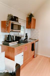 a kitchen with a counter top with a microwave at The Mountain View Cottage in The Patch