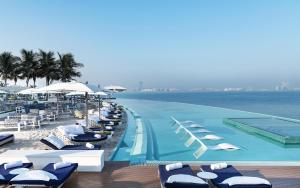 a swimming pool with chaise lounges and chairs on the beach at Burj Al Arab Jumeirah in Dubai