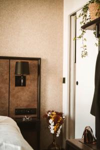 a bedroom with a bed and a lamp and a vase of flowers at La Maison Montparnasse in Paris