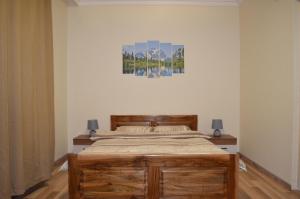 a bedroom with a bed and a painting on the wall at Villa Bella - A Rila Monastery Adventure in Kocherinovo