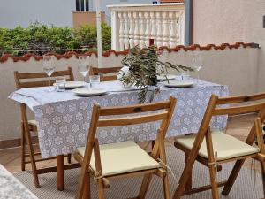 a table with chairs and a table with wine glasses at Villa SeaBreeze in Rogoznica