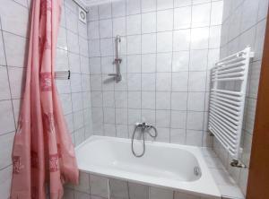 a bathroom with a tub with a shower curtain at Ildiko Apartmanhaz in Zamárdi