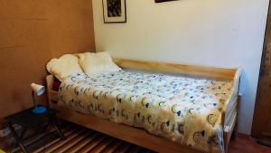 Ce petit lit se trouve dans une chambre dotée d'un couvre-lit. dans l'établissement UNE MAISON SUR UNE PRESQU'ILE, à Port-Saint-Louis-du-Rhône