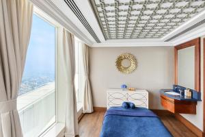 a bedroom with a blue bed and a large window at Jumeirah Burj Al Arab Dubai in Dubai