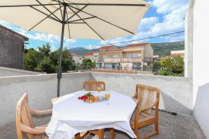 - une table avec un parasol et un bol de fruits dans l'établissement Apartment Lucy by the sea with a private pool, à Kaštela