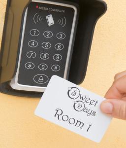 uma mão segurando um pedaço de papel ao lado de um controle remoto em Relais Sweet Days em Peschiera del Garda