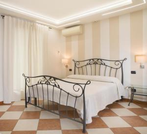 ein Schlafzimmer mit einem Bett und einem karierten Boden in der Unterkunft Relais Sweet Days in Peschiera del Garda