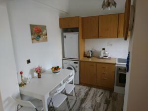 a kitchen with a white table and white appliances at Sunny family apartment in Chania close to the sea in Chania Town +33 photos