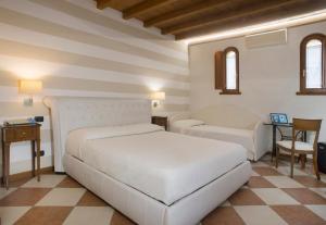 um quarto com duas camas, uma mesa e cadeiras em Relais Sweet Days em Peschiera del Garda