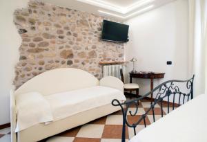 a living room with a white couch and a stone wall at Relais Sweet Days in Peschiera del Garda