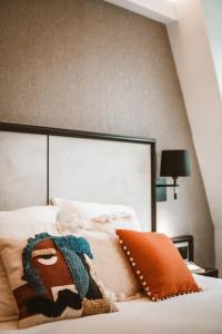a bed with a large headboard and a pillow on it at La Maison Montparnasse in Paris