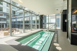 a large swimming pool in a building with windows at Modern Lillian St Apartments by GLOBALSTAY in Toronto