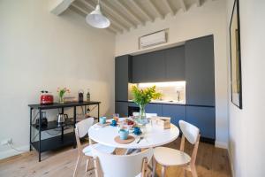 eine Küche und ein Esszimmer mit einem weißen Tisch und Stühlen in der Unterkunft CasadiMaru in Pietrasanta