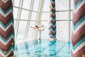 a woman dancing in a room with a large window at Jumeirah Burj Al Arab Dubai in Dubai