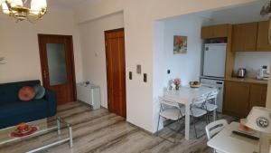 a living room with a table and a kitchen at Sunny family apartment in Chania close to the sea in Chania