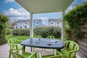 een blauwe tafel en stoelen op een patio bij L'Alouette - Appt en résidence avec terrasse in Courseulles-sur-Mer