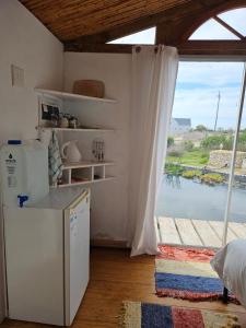 a kitchen with a refrigerator and a large window at Aintree Lodge - Yoga Den in Langebaan