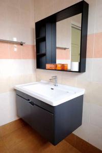 a bathroom with a white sink and a mirror at Puchong Landed Homestay - 1st unit @ BKT Puchong in Puchong