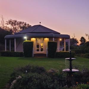 een huis met een fontein voor een tuin bij Mistress Block Vineyard in Pokolbin