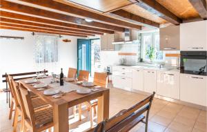 uma grande cozinha com uma mesa de madeira e cadeiras em Gorgeous Home In Lokvicici With Wifi em Lokvičič