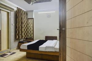 Un dormitorio con una cama y una puerta corredera en Collection O Udit Plaza, en Bhopal