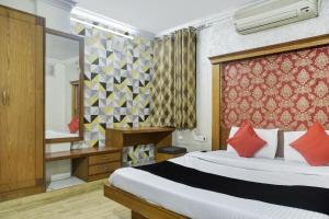 a hotel room with a bed and a mirror at Collection O Hotel Udit Plaza in Bhopal
