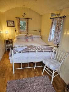 a bedroom with a bed and a chair in a room at Glamping At The Fox Inn Bramdean in Bramdean