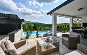 eine Terrasse mit einem Tisch, Stühlen und einem Pool in der Unterkunft Beautiful Home In Stubicke Toplice With Outdoor Swimming Pool in Stubicke Toplice