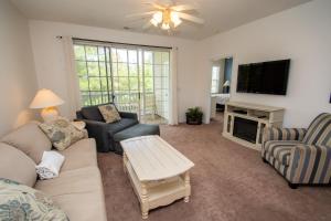a living room with a couch and a tv at Iron Wood 1721 by Palmetto Vacation Rentals in Myrtle Beach