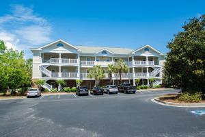 a large white building with cars parked in a parking lot at Iron Wood 1721 by Palmetto Vacation Rentals in Myrtle Beach
