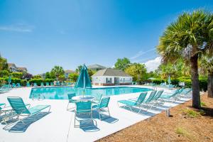 a pool with chairs and a table and umbrella at Iron Wood 1721 by Palmetto Vacation Rentals in Myrtle Beach