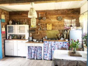 cocina con electrodomésticos blancos y paredes de madera en Magiczne Podlasie 