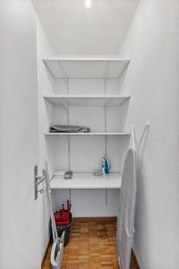 uma casa de banho com prateleiras brancas e um WC num quarto em Beautiful Boutique Apartment DRAHTZUG16 em Zürich