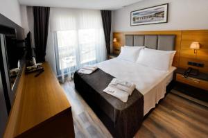 Una habitación de hotel con una cama con dos toallas. en EMAY OTEL, en Trabzon