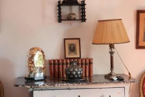 a table with a lamp and a group of books at La Nesquière Chambres d'Hôtes in Pernes-les-Fontaines