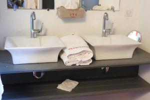 dois lavatórios numa casa de banho com toalhas num balcão em La Nesquière Chambres d'Hôtes em Pernes-les-Fontaines