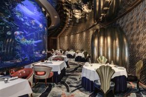 a dining room with tables and an aquarium at Jumeirah Burj Al Arab Dubai in Dubai