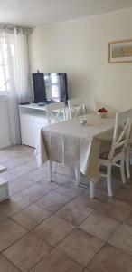 a dining room with a table and chairs and a tv at Bergland apartment 18 - close to the center of Kragerø in Kragerø