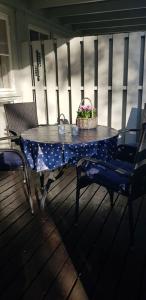 a table on a porch with two chairs and a basket of flowers at Bergland apartment 18 - close to the center of Kragerø in Kragerø