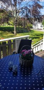 a blue table with a basket of flowers on it at Bergland apartment 18 - close to the center of Kragerø in Kragerø