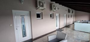 Pokój z białymi ścianami, białymi drzwiami i krzesłami w obiekcie Azra Apartman w mieście Harkány