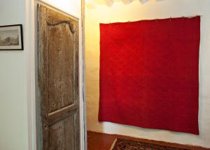 uma cortina vermelha numa parede ao lado de uma porta em La Nesquière Chambres d'Hôtes em Pernes-les-Fontaines