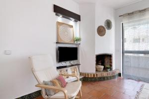 een woonkamer met een tv en een open haard bij Mar azul 3 in Albufeira